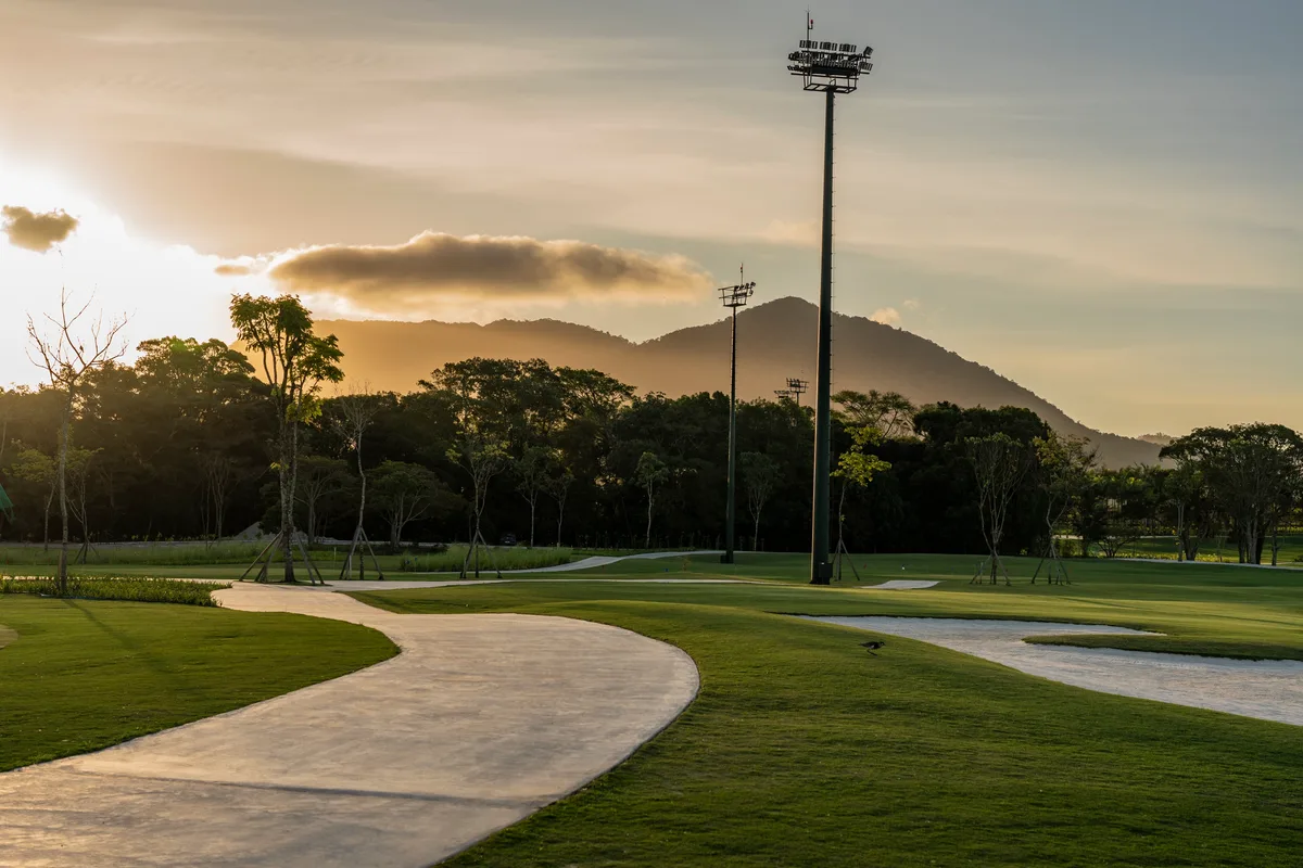 Campo de golfe do ALL Resort ao pôr do sol, com as torres de iluminação